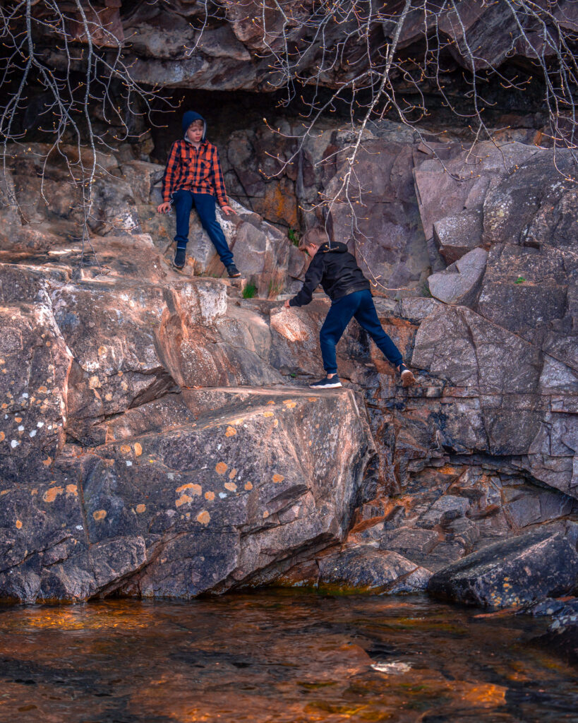 Omberg-kid-on-rocks-beside-Lake-Vattern-climbing